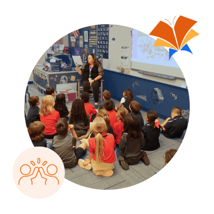 Teacher reading to class of student sitting on floor (1)