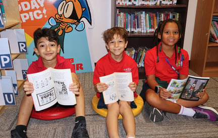 three students on the floor with their books